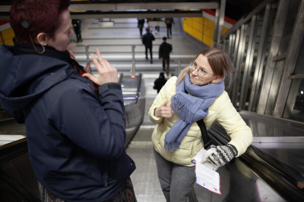 Sisäkorvaistutteen käyttäjä Lumo Kumpulainen viittoo Aino Laiholle metron tunnelin liukuportaissa.