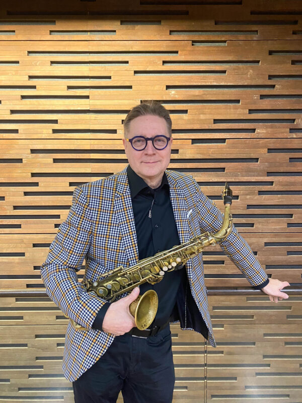 Jari Perkiömäki poseeraa saksofonin kanssa.