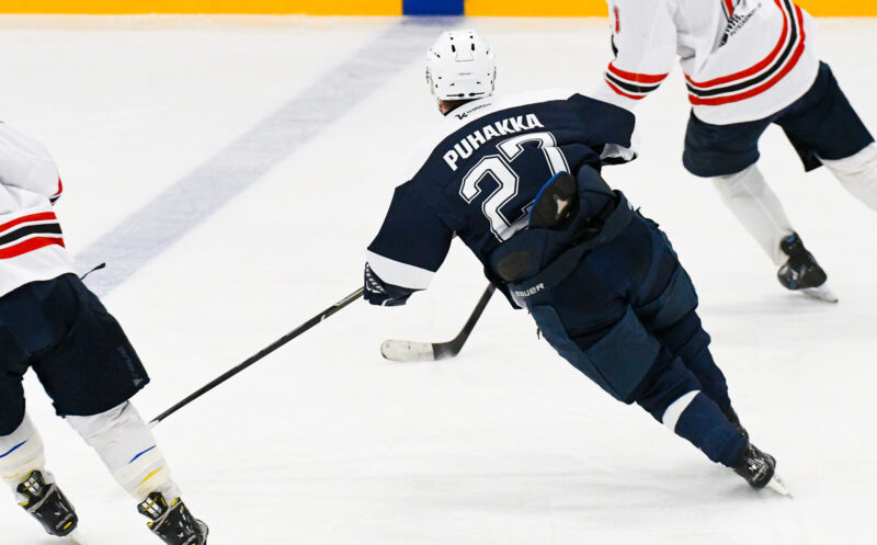 Joona Puhakka luistelee Kirkkonummen jäähallissa sinisessä pelipaidassa selkä kameraan päin.